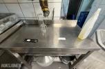 Arbeidsbenk i rustfritt stål med kokekar og kjøkkenutstyr